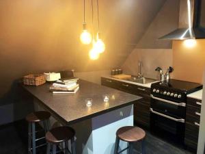 a kitchen with a stove and a counter with stools at Boutique Loft Apartment in Dunkeld