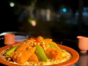 a plate of food with vegetables on a table at Maison D'hôtes Ait Mouli in Bzou