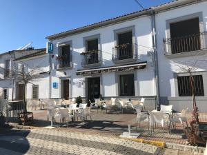 un edificio blanco con mesas y sillas delante en Hostal Los Encinares, en Villanueva de Córdoba