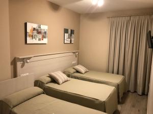 pokój z dwoma łóżkami i oknem w obiekcie Hostal Los Encinares w mieście Villanueva de Córdoba