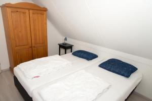 a bedroom with two beds and a wooden cabinet at Hello Zeeland - Vakantiehuis Zwin 218 in Breskens