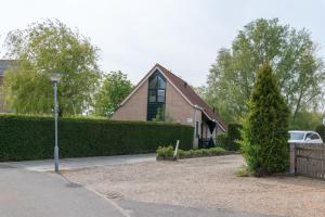 uma casa com uma luz de rua em frente a uma entrada em Hello Zeeland - Vakantiehuis Zwin 218 em Breskens