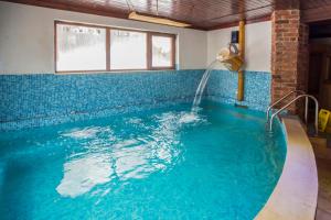 a swimming pool with a water fountain in a room at Shtastlivcite Family Hotel in Starozagorski Bani