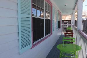 een veranda met een groene tafel en stoelen bij Caribbean House in Key West