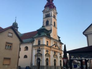 ein großes Gebäude mit einem Uhrturm oben in der Unterkunft Cozy, Bright and Affordable Single Studio - Free Parking in Ljubljana