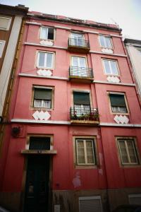 リスボンにあるFernando Pessoa Lisbon Roomsの窓とバルコニー付きの赤い建物