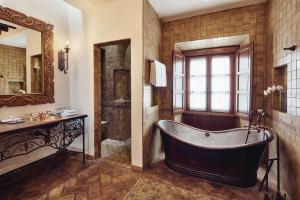 ein Badezimmer mit einer Badewanne, einem Waschbecken und einem Spiegel in der Unterkunft Casa de Sierra Nevada, A Belmond Hotel, San Miguel de Allende in San Miguel de Allende