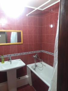 baño de azulejos rojos con lavabo y bañera en Просторная 1комнатня квартира напротив ТРЦ Дафи Ашан рядом ресторан Альтбир, en Járkov