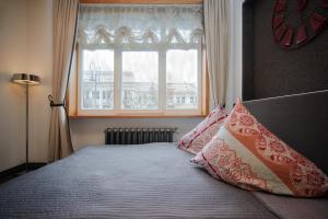 a bedroom with a bed with pillows and a window at Town Hall Apartments in Vilnius