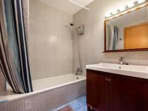 a bathroom with a tub and a sink and a mirror at Stay Barcelona Maragall in Barcelona