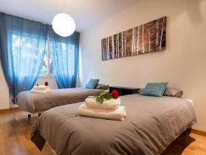 two beds in a room with blue curtains at Stay Barcelona Maragall in Barcelona