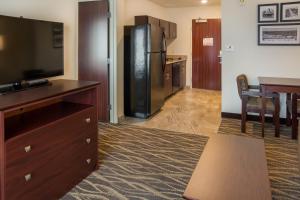 a living room with a television and a kitchen at Cobblestone Inn and Suites - Ashland in Ashland