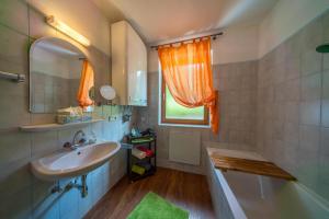 a bathroom with a sink and a tub and a mirror at Ferienwohnungen Fischerhaus - direkt am See in Millstatt