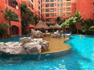 ein Pool in einem Hotel mit Felsen im Wasser in der Unterkunft Seven Seas Condo Resort in Jomtien Beach