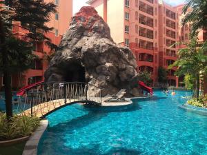 ein Pool in einem Hotel mit einer Wasserrutsche in der Unterkunft Seven Seas Condo Resort in Jomtien Beach