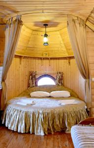 Cama en habitación con techo de madera en Castle Belvedere, en Bukovel