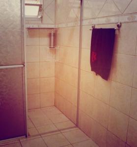 a bathroom with a shower with a red towel at Hostel Nossa Casa in Florianópolis