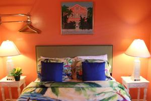 a bedroom with orange walls and a bed with blue pillows at Caribbean House, No Resort Fees in Key West