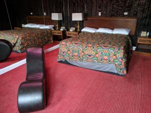 two beds in a hotel room with red carpet at Skylark Motel in Chicago