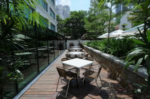 uma fila de mesas e cadeiras num deque de madeira em Micasa All Suites Hotel em Kuala Lumpur