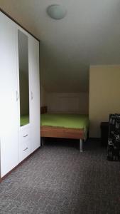 グラール・ミューリッツにあるKlünnersheimのベッドルーム(緑のベッド1台、ドレッサー付)