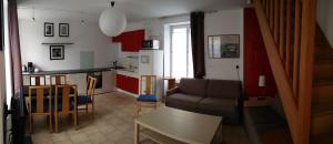 een keuken en een woonkamer met een bank en een tafel bij Les Fontaines in Baron