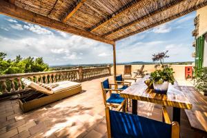 een patio met een houten tafel en stoelen bij Finca Rural Son Amer in Manacor