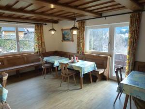 a dining room with two tables and two windows at Ferienhaus Sonnberg in Fieberbrunn