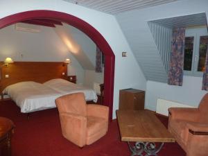 ein Hotelzimmer mit einem Bett und einem Stuhl in der Unterkunft Chez Norbert in Bergheim