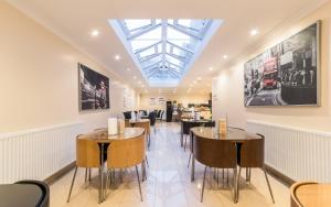 a restaurant with tables and chairs and a skylight at Royal London Hotel By Saba in London
