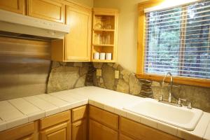 a kitchen with wooden cabinets and a sink and a window at Shaver Lake Village Hotel in Shaver Lake