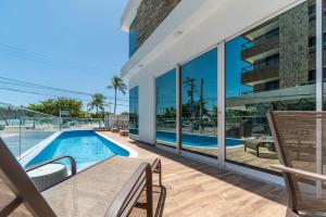 a house with a swimming pool and a balcony at Hotel Praia Bonita Jangadeiros Pajuçara in Maceió