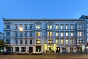 ein großes weißes Gebäude, vor dem Autos parkten in der Unterkunft Hotel Tiergarten Berlin in Berlin