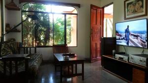 a living room with a couch and a tv at Embassy House in Puerto Jiménez