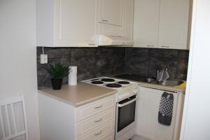 a kitchen with white cabinets and a stove top oven at Hamina Orange Apartments Kadetti 1 in Hamina