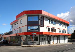 a white and red building on the corner of a street at Hotel Milan Costa Rica in San José