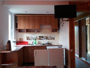 a kitchen with wooden cabinets and a tv on the wall at Смериковий in Yaremche