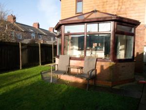 a conservatory with two chairs and a table in a yard at The Old Forge, Trafalgar Court in York