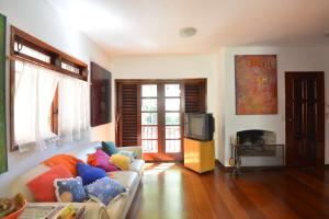 ein Wohnzimmer mit einem Sofa und einem TV in der Unterkunft Maestro Ibirapuera Park in São Paulo