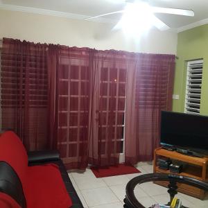 a living room with red curtains and a tv at 1002 Crystal Court Condominiums in Saint James