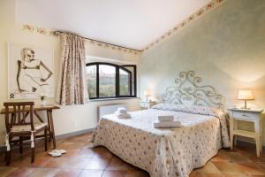 um quarto com uma cama, uma cadeira e uma janela em B&B Ponte a Nappo San Gimignano em San Gimignano