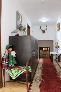 a doll sitting on a chair in a living room at Pensiunea Nituca in Moisei +31 photos