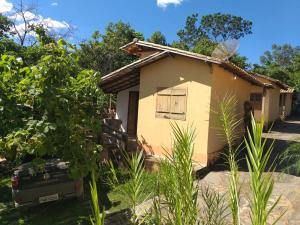 una pequeña casa con un coche aparcado delante de ella en CHALÉS MUCIOS, en Serra do Cipo