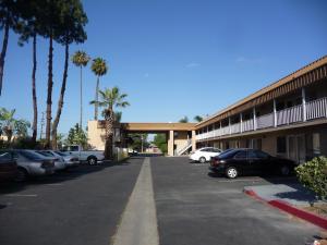 un estacionamiento con autos estacionados frente a un motel en Rainbow Inn en Anaheim