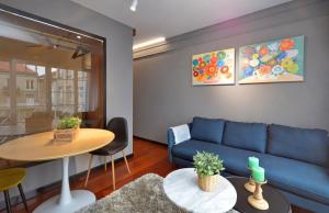 a living room with a blue couch and a table at SUITE DE LUJO-CENTRO Kilometro 0-PARKING in Vigo