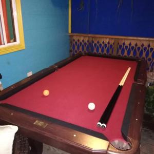 a pool table with two balls on top of it at Cliff's Hostel in La Gruta