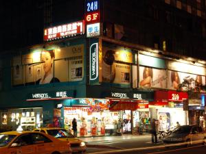 un edificio con anuncios al lado de una calle por la noche en 東鑫商務旅館Eastern Star Hotel en Taipéi
