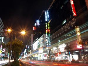 a busy city street at night with neon signs at 東鑫商務旅館Eastern Star Hotel in Taipei
