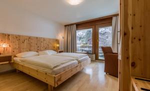 ein Schlafzimmer mit einem großen Bett und einem großen Fenster in der Unterkunft Sporthotel Walliserhof in Unterbäch