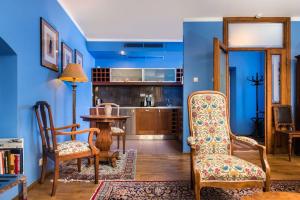 a living room with blue walls and a table and chairs at Orlowska Townhouse Apartments in Kraków
